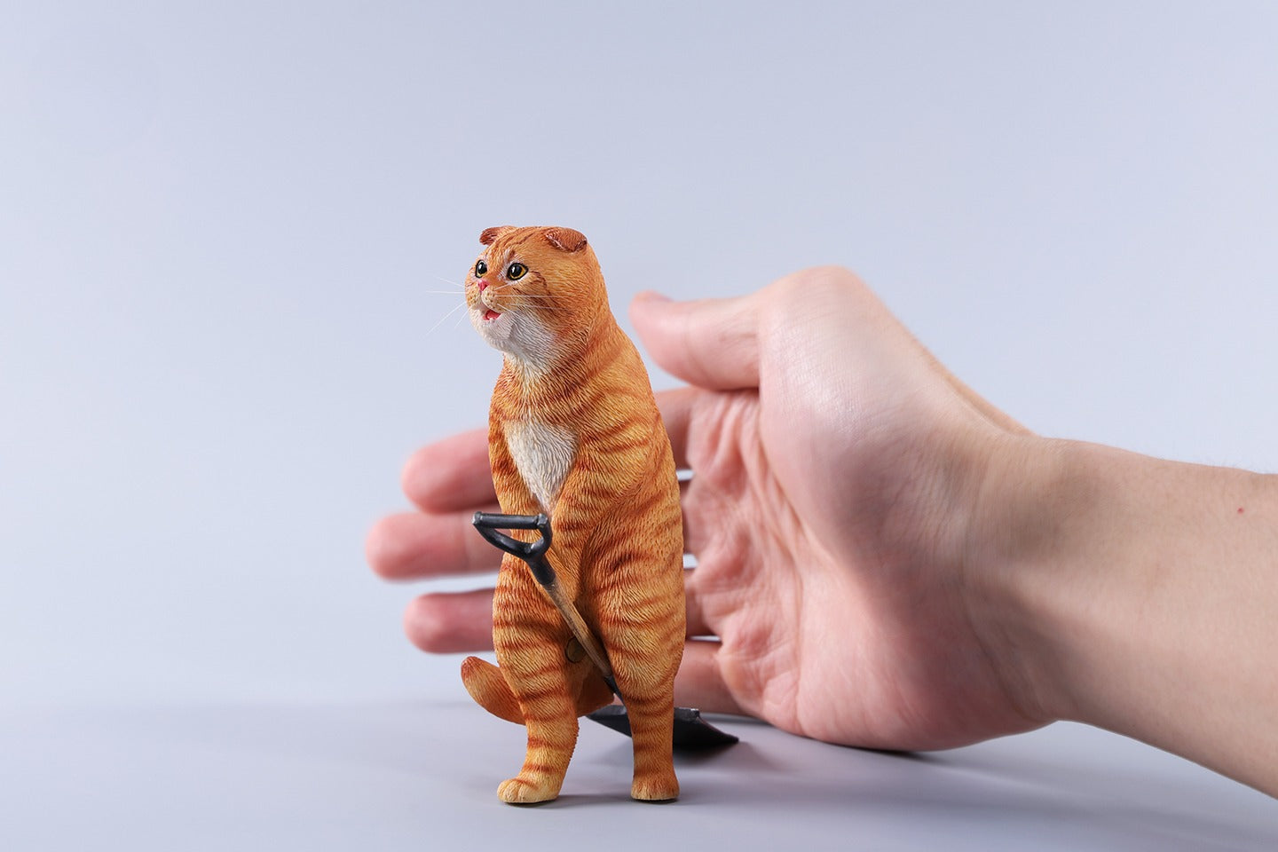 A realistic 1/6 scale folded eared cat figurine with a mouse on a spade, handcrafted from resin and hand-painted to capture lifelike details.