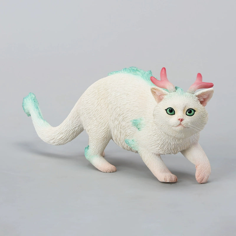 A highly detailed Catragon Figurine featuring a white feline with dragon-like features, including pastel green fur accents and delicate horns. This resin-crafted fantasy cat-dragon hybrid is an artistic and whimsical collectible. Ideal for display or as a gift for cat lovers and fantasy enthusiasts.