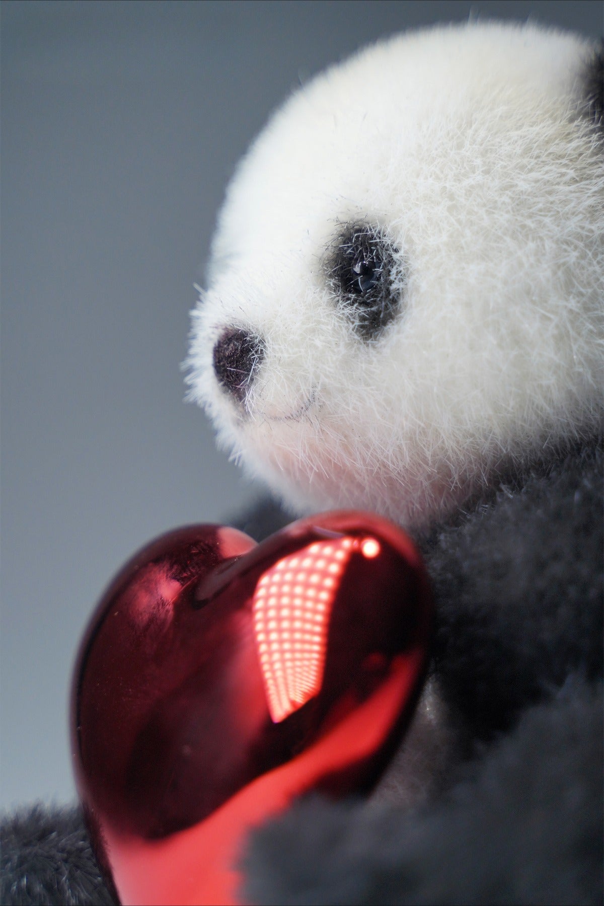 This cute panda figurine holds a shiny red heart ornament, perfect for panda lovers. Its soft and detailed resin design adds charm to any space, making it a delightful gift idea for all ages.