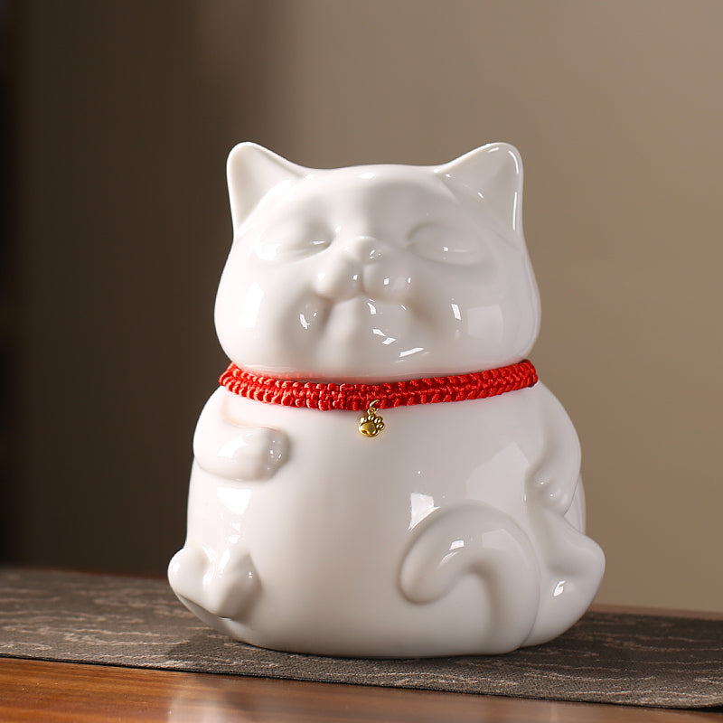 A ceramic cat urn designed for pet ashes, featuring a cute cat with a red collar and a golden bell. It offers a secure and comforting place for your pet's ashes, acting as both a memorial and a sentimental keepsake for grieving pet owners.
