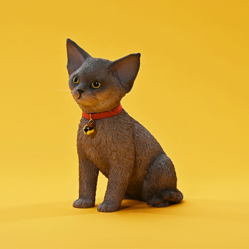 A set of 1/3 scale German Curly Cat resin models featuring five cats with distinct fur colors and patterns. The cats are shown sitting attentively around a pair of human legs, wearing red collars with bells. The scene is set against a yellow background.