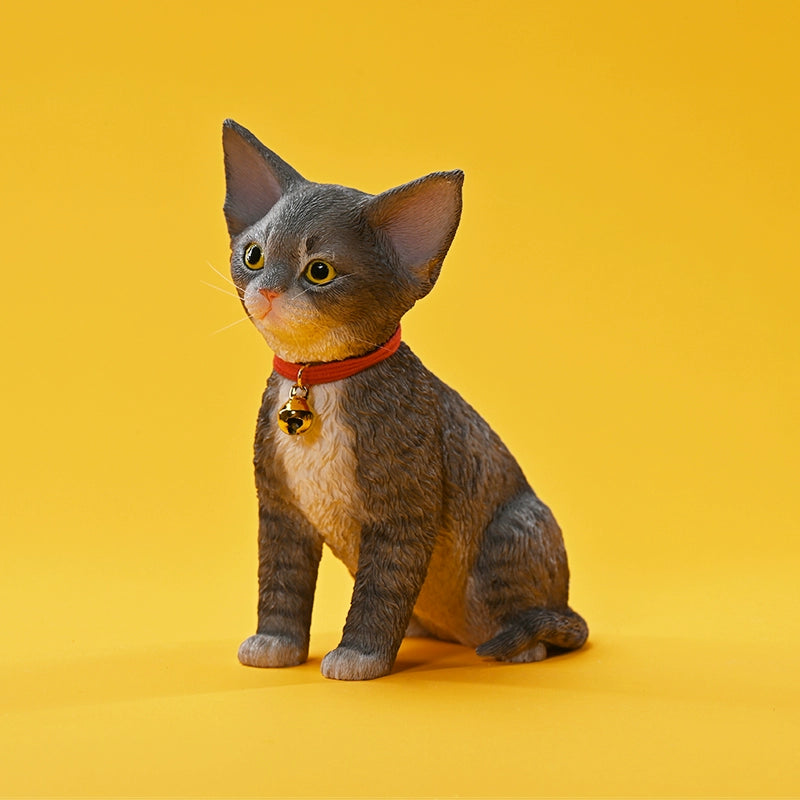 A set of 1/3 scale German Curly Cat resin models featuring five cats with distinct fur colors and patterns. The cats are shown sitting attentively around a pair of human legs, wearing red collars with bells. The scene is set against a yellow background.