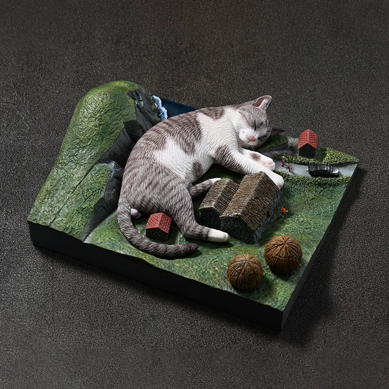 A 1/6 scale model of a giant orange tabby cat sleeping peacefully on a miniature landscape. The scene features small houses, roads, and other objects, emphasizing the cat's enormous size in a whimsical and imaginative setting.