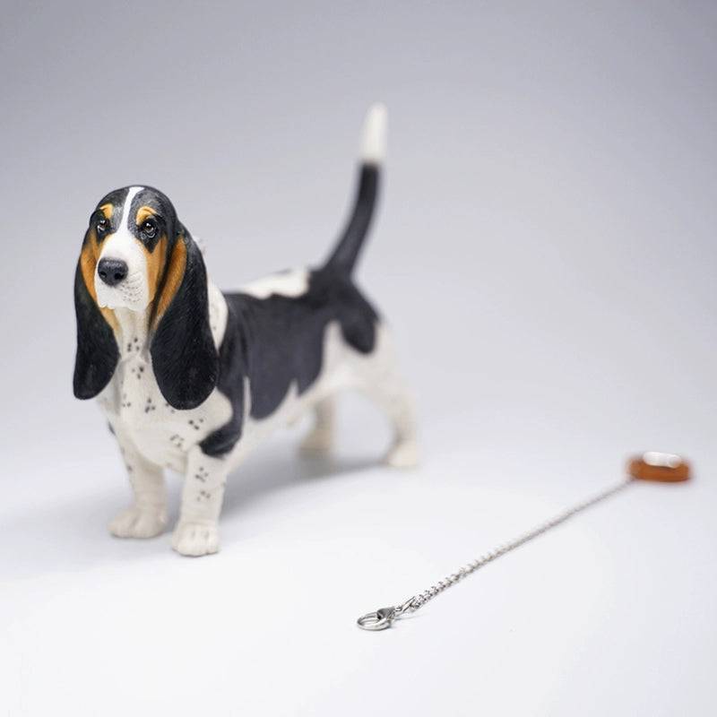 A set of four 1/6 scale models of Basset Hound dogs, each with different coat colors and patterns. The models feature the breed's distinctive long ears, droopy eyes, and short legs, capturing their unique and charming appearance.