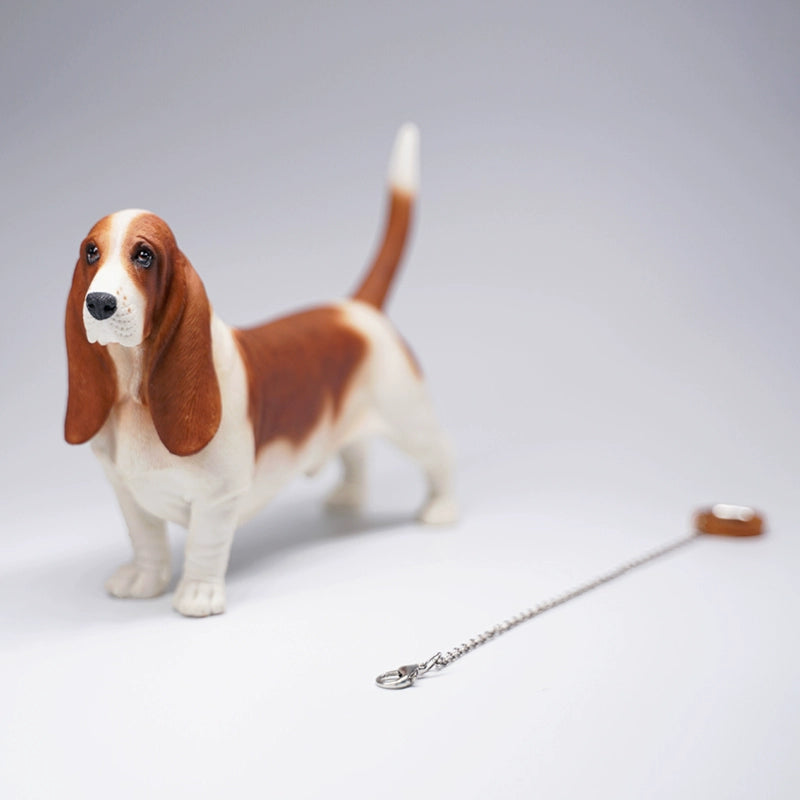 A set of four 1/6 scale models of Basset Hound dogs, each with different coat colors and patterns. The models feature the breed's distinctive long ears, droopy eyes, and short legs, capturing their unique and charming appearance.