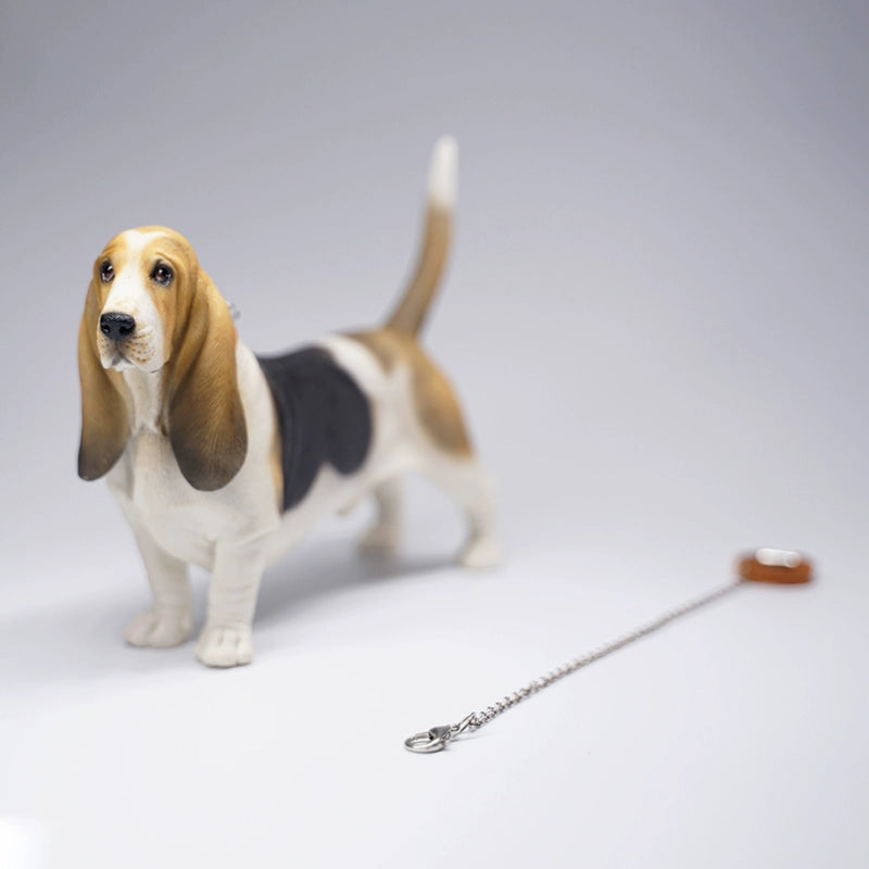 A set of four 1/6 scale models of Basset Hound dogs, each with different coat colors and patterns. The models feature the breed's distinctive long ears, droopy eyes, and short legs, capturing their unique and charming appearance.