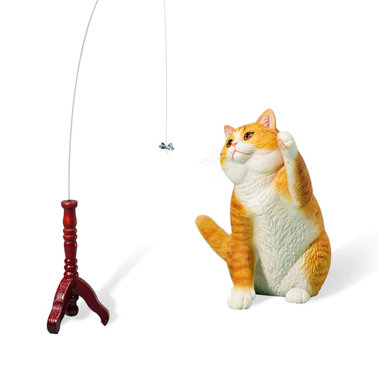 A 1/6 scale model of a white British Shorthair cat playing with a toy hanging from a stand. The cat has a fluffy coat and is depicted with a playful expression, raising one paw towards the toy.