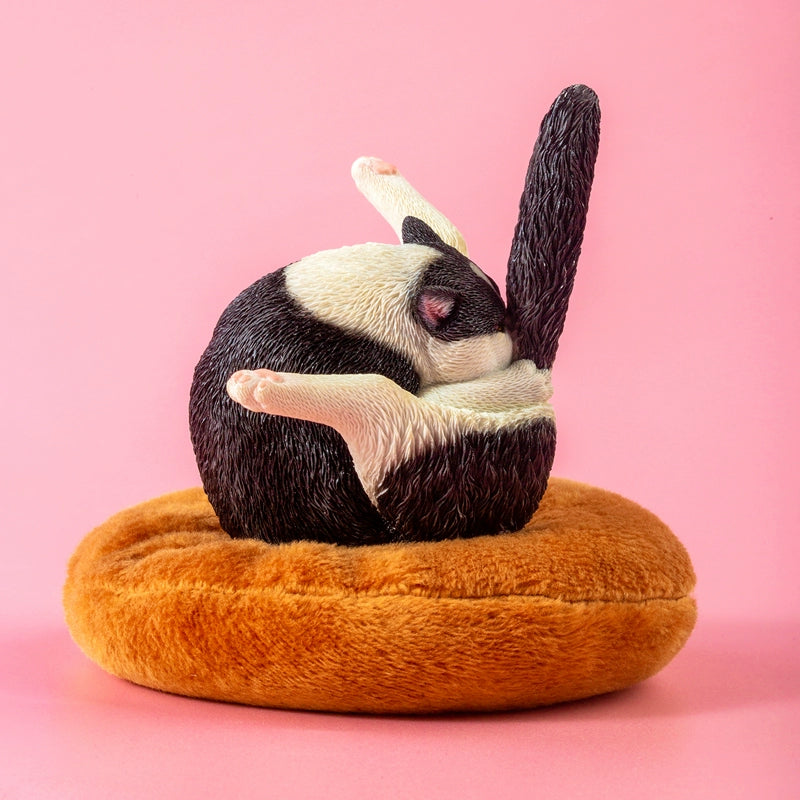 "A set of five 1/6 scale cat models humorously designed to resemble chicken legs. Each cat is curled up in a round, resting position on a plush, brown cushion, showcasing different fur colors and patterns, including grey, black and white, orange, and cream."