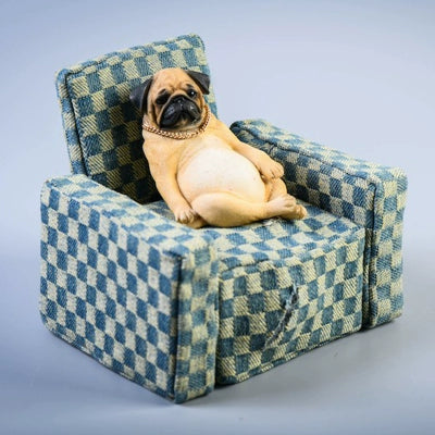 "A set of four 1/6 scale Pug dog models in different poses, sitting on a patterned blue armchair, showcasing a relaxed and decadent style."