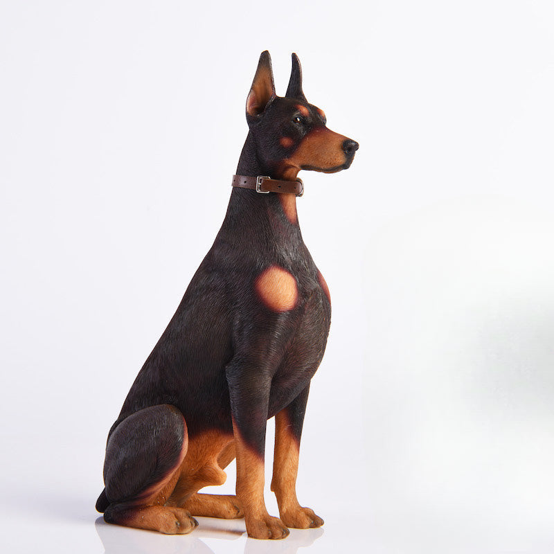 "A set of two 1/6 scale Doberman Pinscher resin models, one sitting and the other lying down, showcasing realistic details and noble posture."
