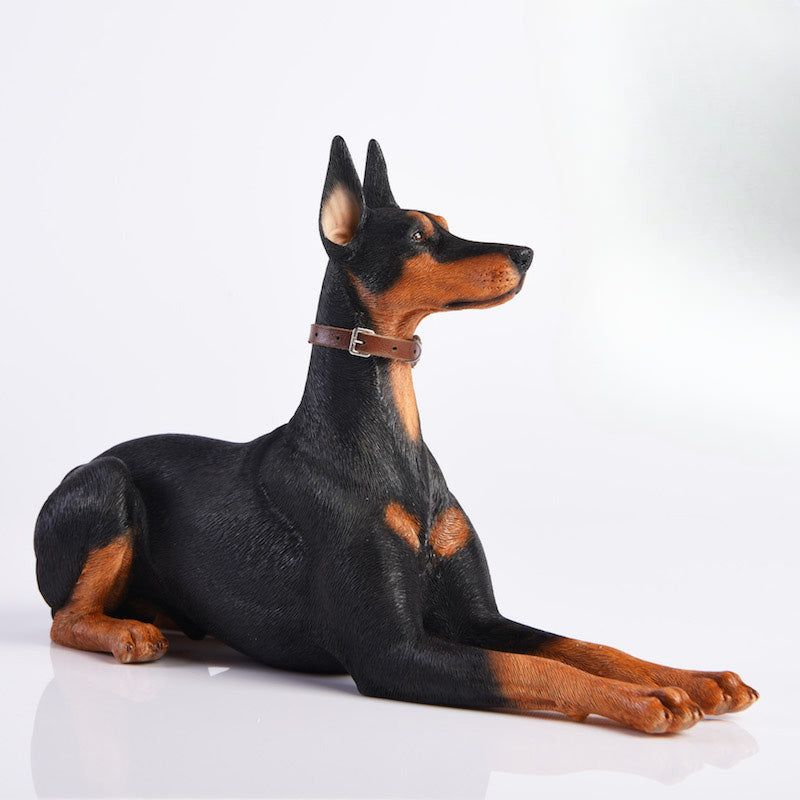 "A set of two 1/6 scale Doberman Pinscher resin models, one sitting and the other lying down, showcasing realistic details and noble posture."