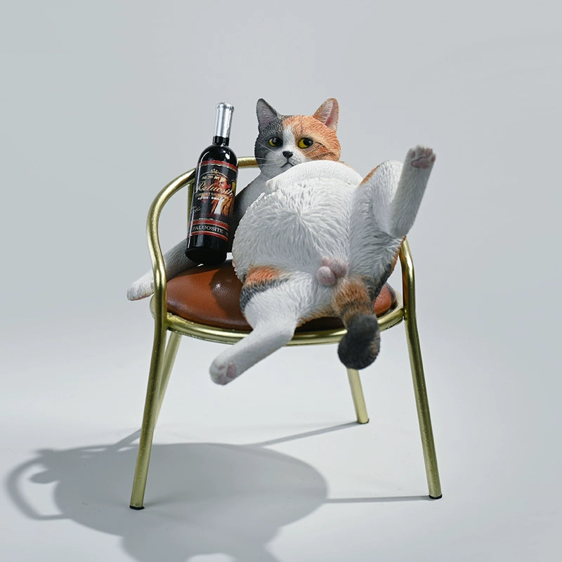 A 1/6 scale figurine of an orange tabby cat lounging on a chair with a bottle, portraying a humorous 'drunk' pose.