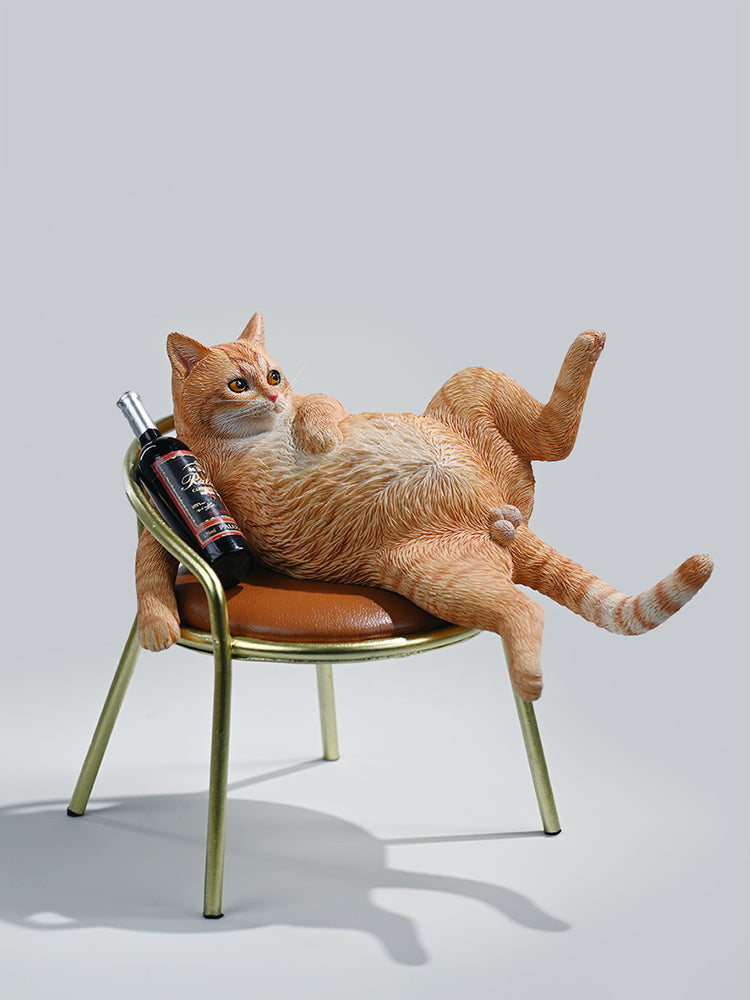 A 1/6 scale figurine of an orange tabby cat lounging on a chair with a bottle, portraying a humorous 'drunk' pose.