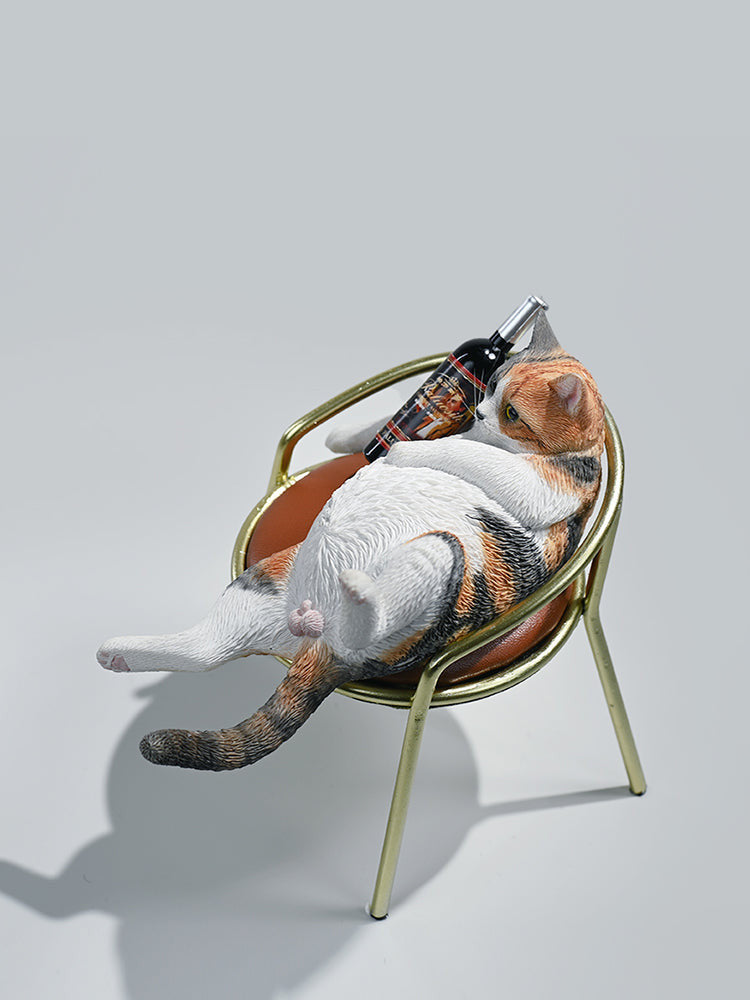 A 1/6 scale figurine of an orange tabby cat lounging on a chair with a bottle, portraying a humorous 'drunk' pose.