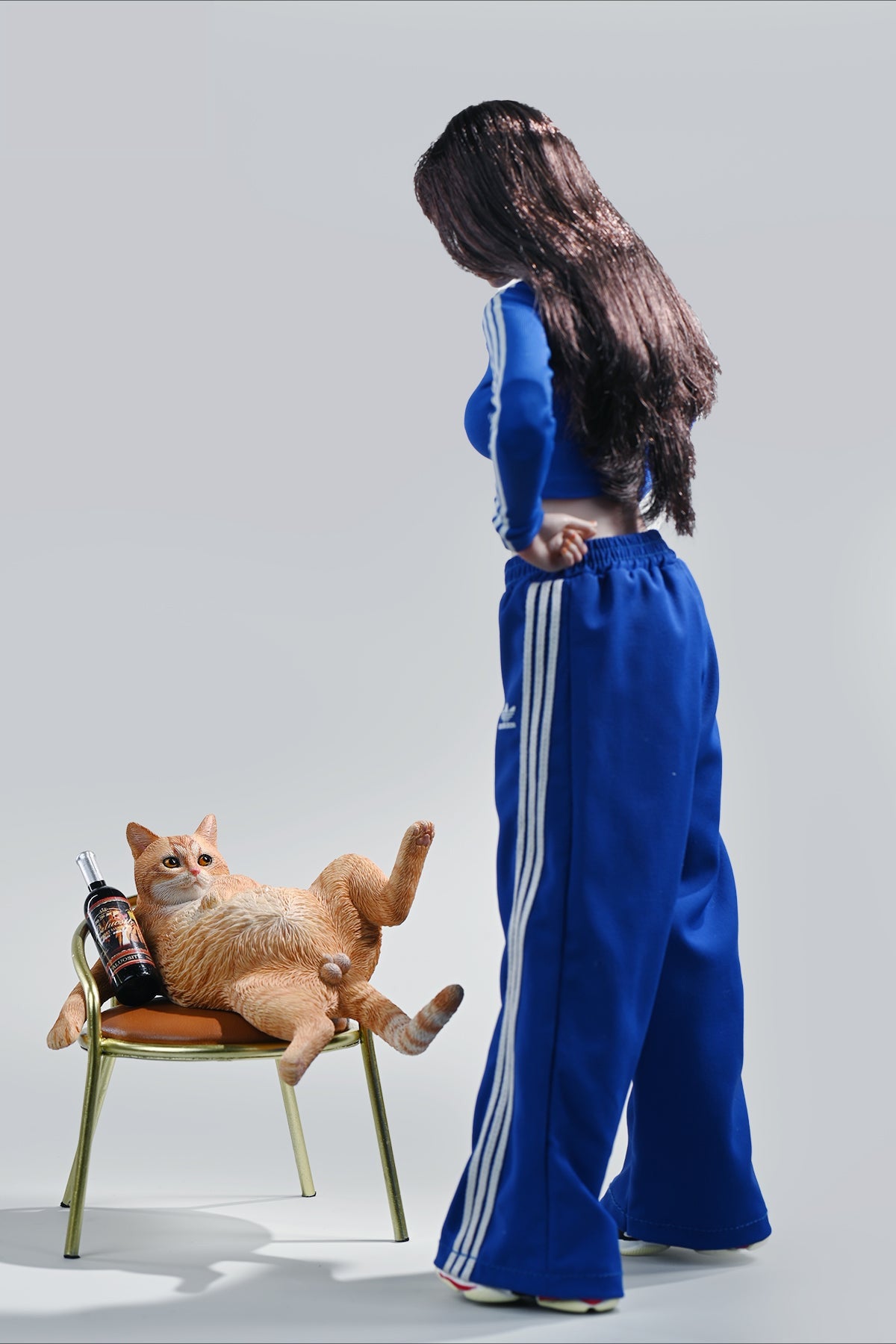 A 1/6 scale figurine of an orange tabby cat lounging on a chair with a bottle, portraying a humorous 'drunk' pose.