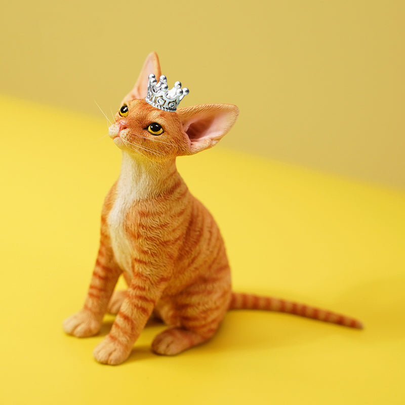 A realistic 1/6 scale German Curly Princess Cat model featuring an orange tabby cat with a crown, elegantly posed among miniature blocks. This figurine captures the regal essence of the cat, making it a perfect collectible for cat enthusiasts and home decor.