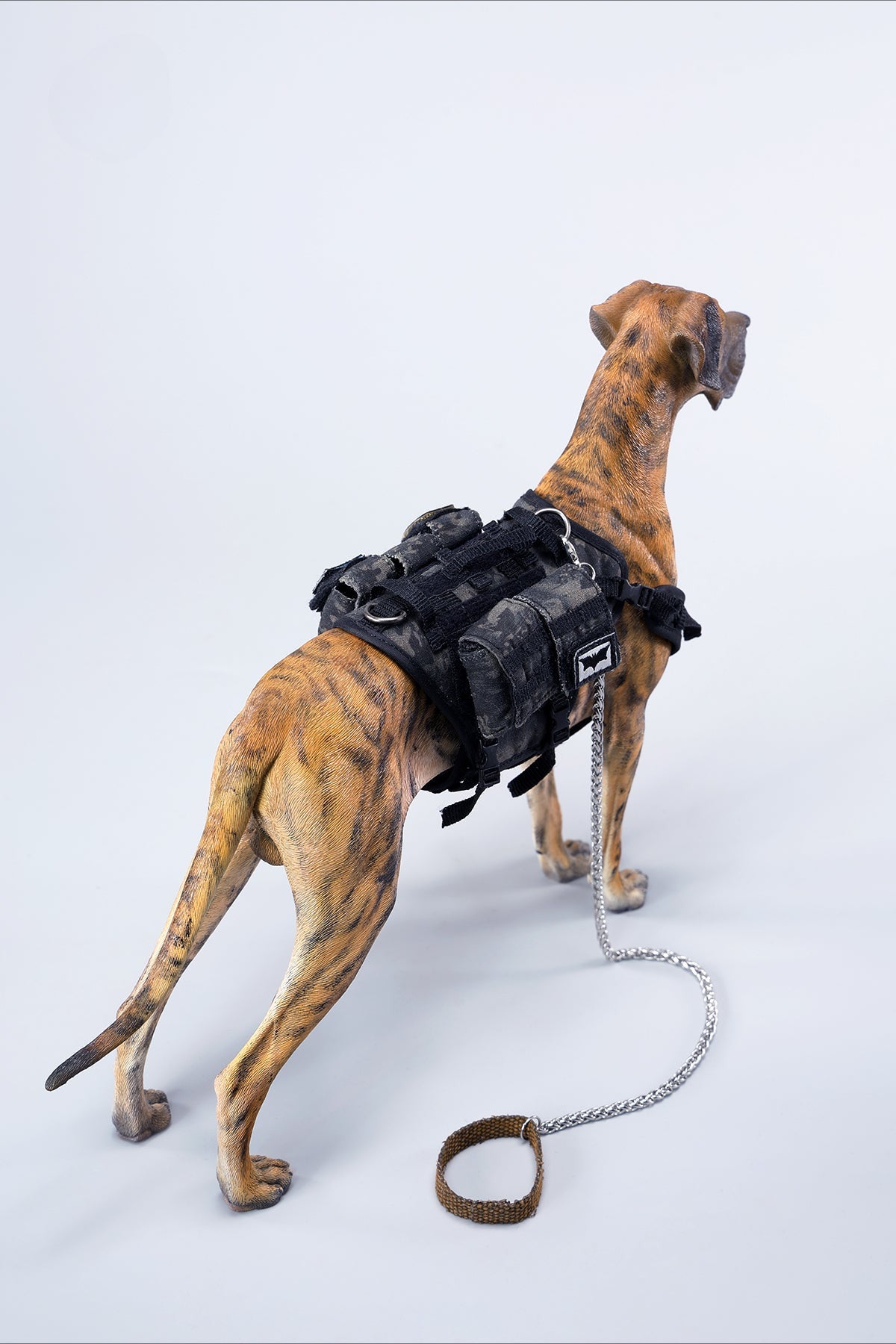 A highly detailed model of a Great Dane dog in four different coat colors: fawn, black, brindle, and gray. The model showcases the Great Dane's majestic stature and muscular build. The second image shows a brindle Great Dane model equipped with a tactical harness and leash, highlighting the dog's strength and readiness for action. This realistic Great Dane figurine is perfect for collectors and dog enthusiasts.