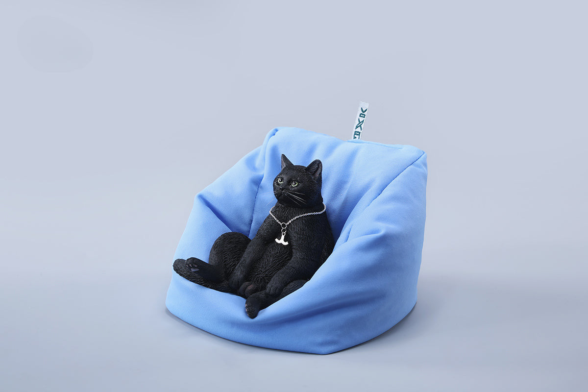 A set of four realistic 1/6 scale lazy cat figurines in different colors, each sitting comfortably with a lifelike expression. The cats are depicted in various coats: calico, grey tabby, orange tabby, and black. One figurine is shown lounging on a blue beanbag, adding to the whimsical charm of the collection.