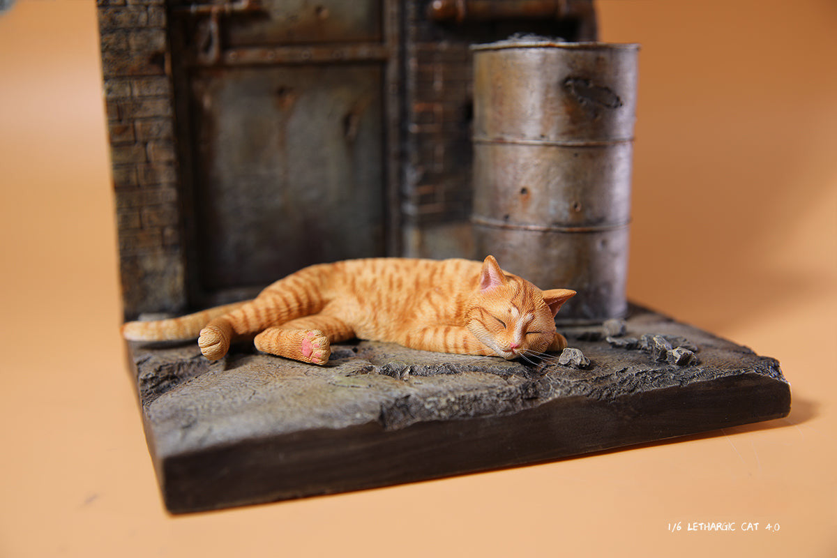 A realistic 1/6 scale model of a relaxed gray cat sleeping on a soft, gray couch, accompanied by two other cat figures lying nearby. The cat figures are detailed with life-like features, capturing their lazy and content postures, perfect for collectors and cat enthusiasts.