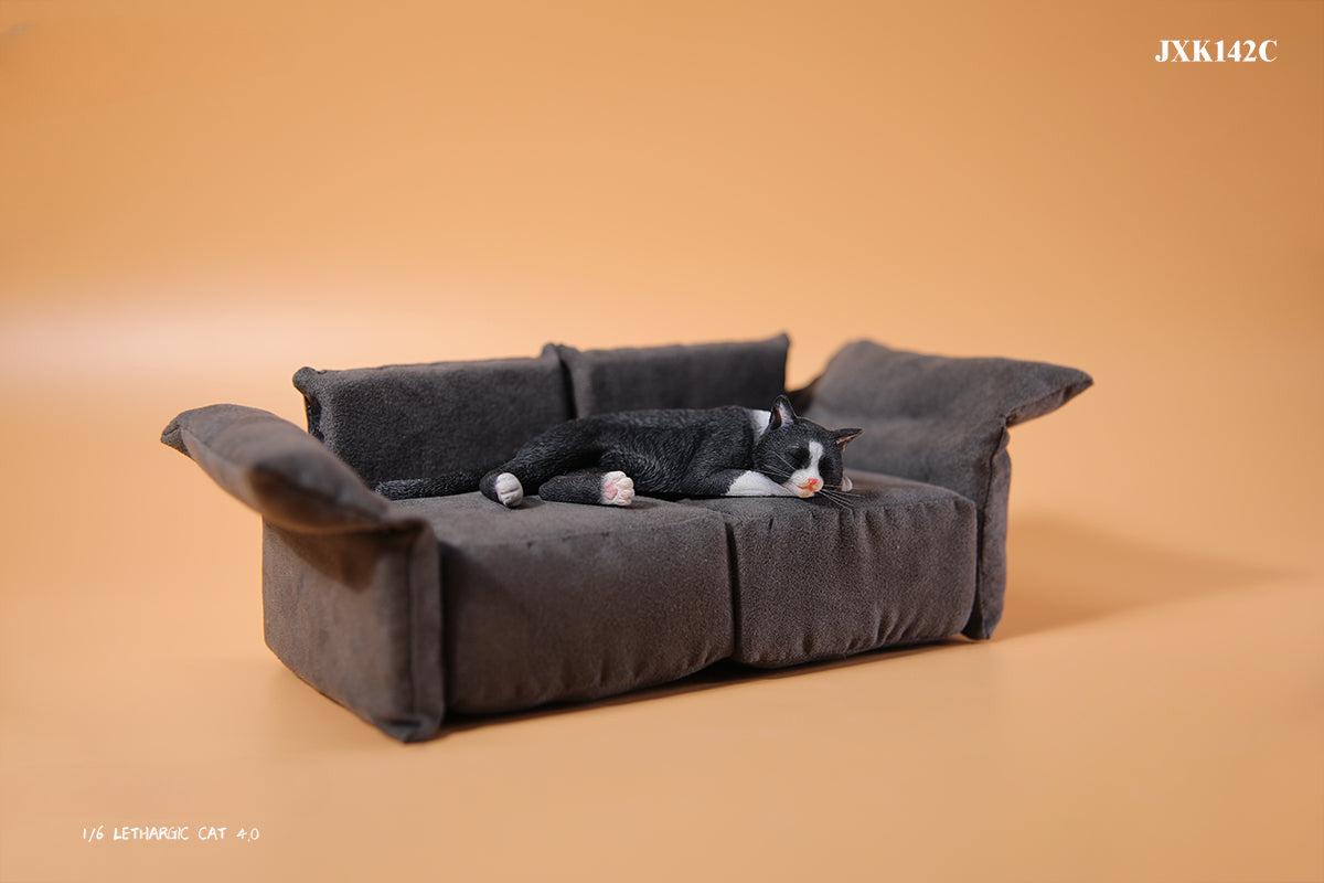 A realistic 1/6 scale model of a relaxed gray cat sleeping on a soft, gray couch, accompanied by two other cat figures lying nearby. The cat figures are detailed with life-like features, capturing their lazy and content postures, perfect for collectors and cat enthusiasts.