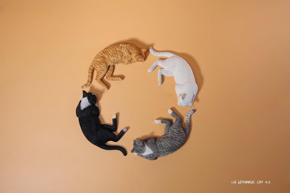 A realistic 1/6 scale model of a relaxed gray cat sleeping on a soft, gray couch, accompanied by two other cat figures lying nearby. The cat figures are detailed with life-like features, capturing their lazy and content postures, perfect for collectors and cat enthusiasts.