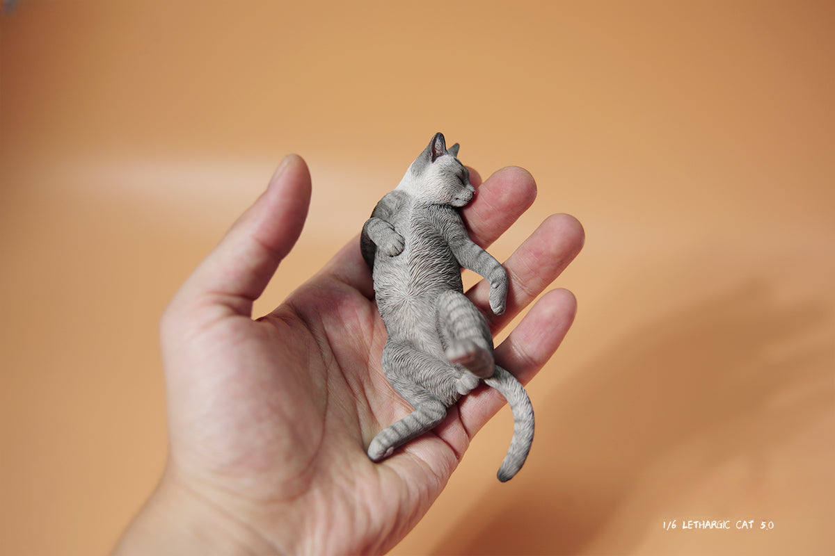 A set of 1/6 scale Lethargic Cat 5.0 models showing various cats in different relaxed, sleeping positions. Each cat is detailed with realistic fur textures and unique coat colors, resting on a grey cushion or a dark grey couch, perfectly capturing the essence of a lazy cat's nap.