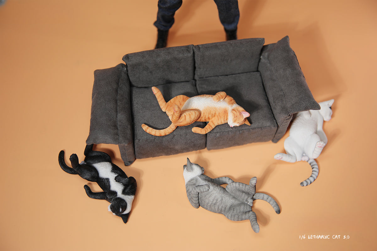 A set of 1/6 scale Lethargic Cat 5.0 models showing various cats in different relaxed, sleeping positions. Each cat is detailed with realistic fur textures and unique coat colors, resting on a grey cushion or a dark grey couch, perfectly capturing the essence of a lazy cat's nap.