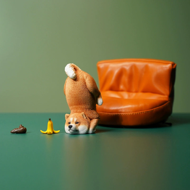 A charming 1/6 scale model of three Shiba Inu dogs, captured in a planking position. Each dog is distinctively colored - black, brown, and white, showcasing intricate detailing from their fur textures to their playful expressions, set against a green background.