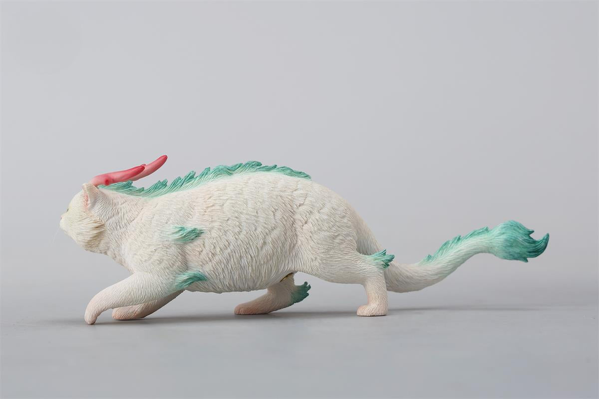 A highly detailed Catragon Figurine featuring a white feline with dragon-like features, including pastel green fur accents and delicate horns. This resin-crafted fantasy cat-dragon hybrid is an artistic and whimsical collectible. Ideal for display or as a gift for cat lovers and fantasy enthusiasts.