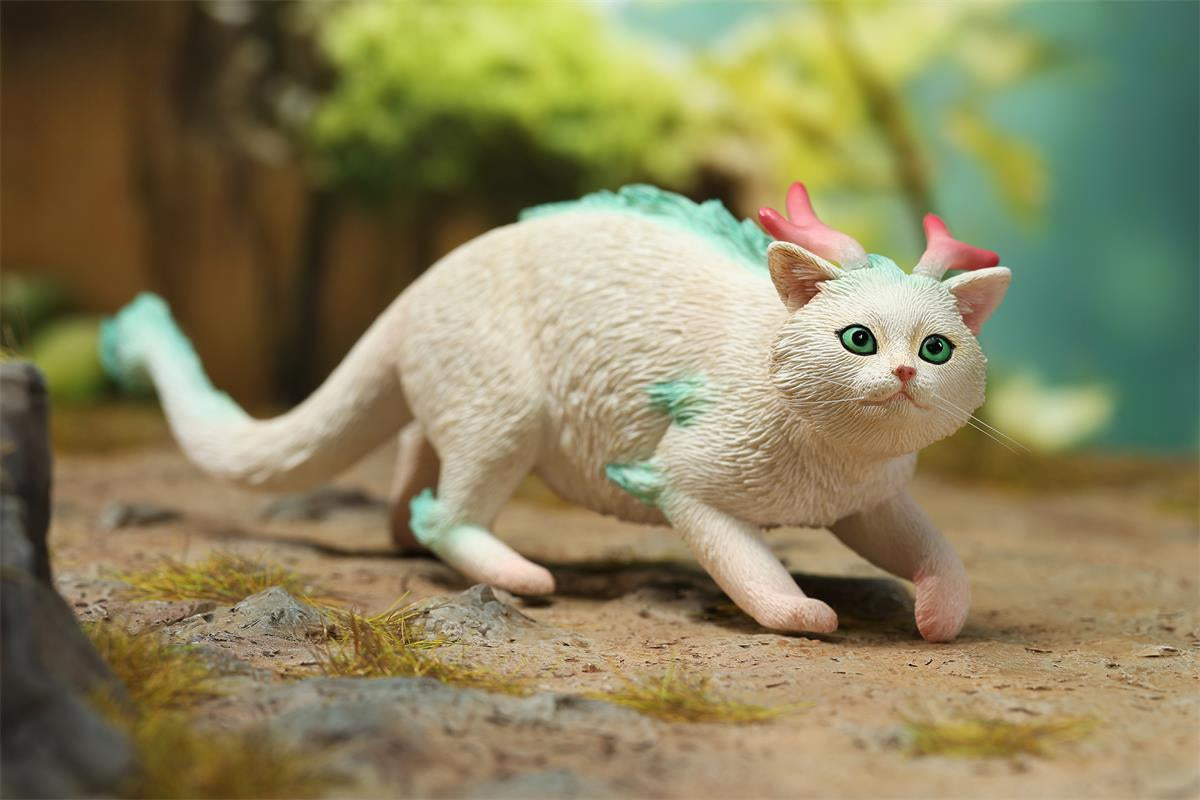 A highly detailed Catragon Figurine featuring a white feline with dragon-like features, including pastel green fur accents and delicate horns. This resin-crafted fantasy cat-dragon hybrid is an artistic and whimsical collectible. Ideal for display or as a gift for cat lovers and fantasy enthusiasts.