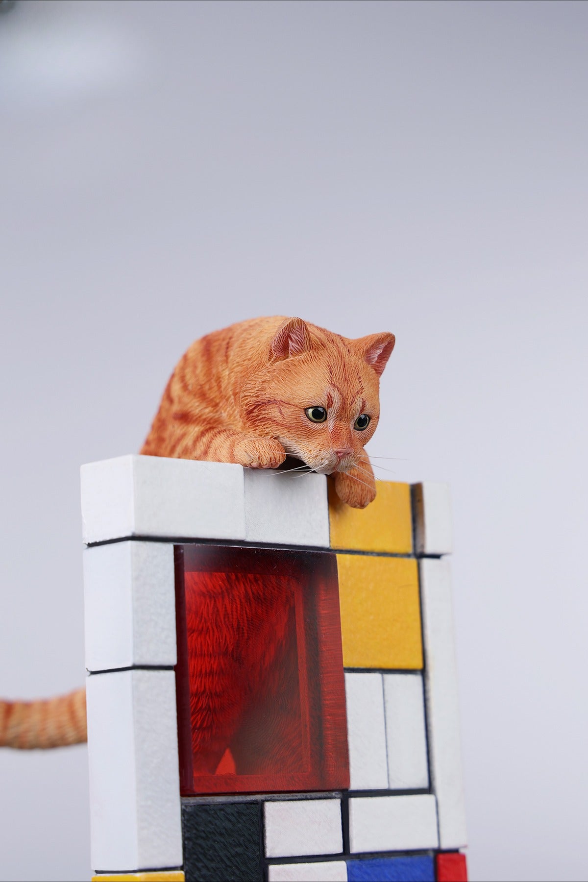 A 1/6 scale Mondrian wall-climbing cat figurine crafted from high-quality resin, featuring a playful cat climbing a colorful cubist-style wall, offering a unique and stylish addition to any home decor.