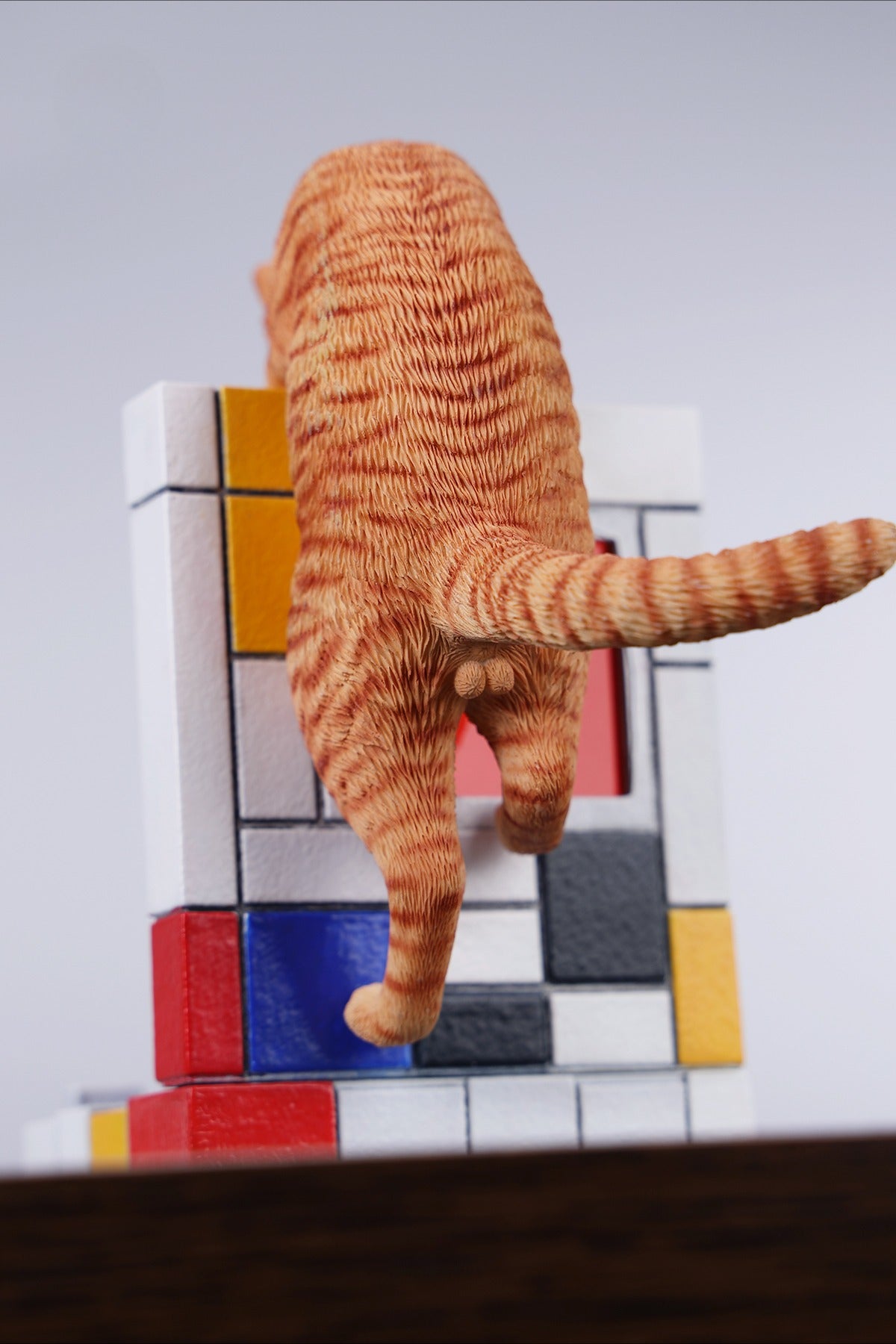 A 1/6 scale Mondrian wall-climbing cat figurine crafted from high-quality resin, featuring a playful cat climbing a colorful cubist-style wall, offering a unique and stylish addition to any home decor.