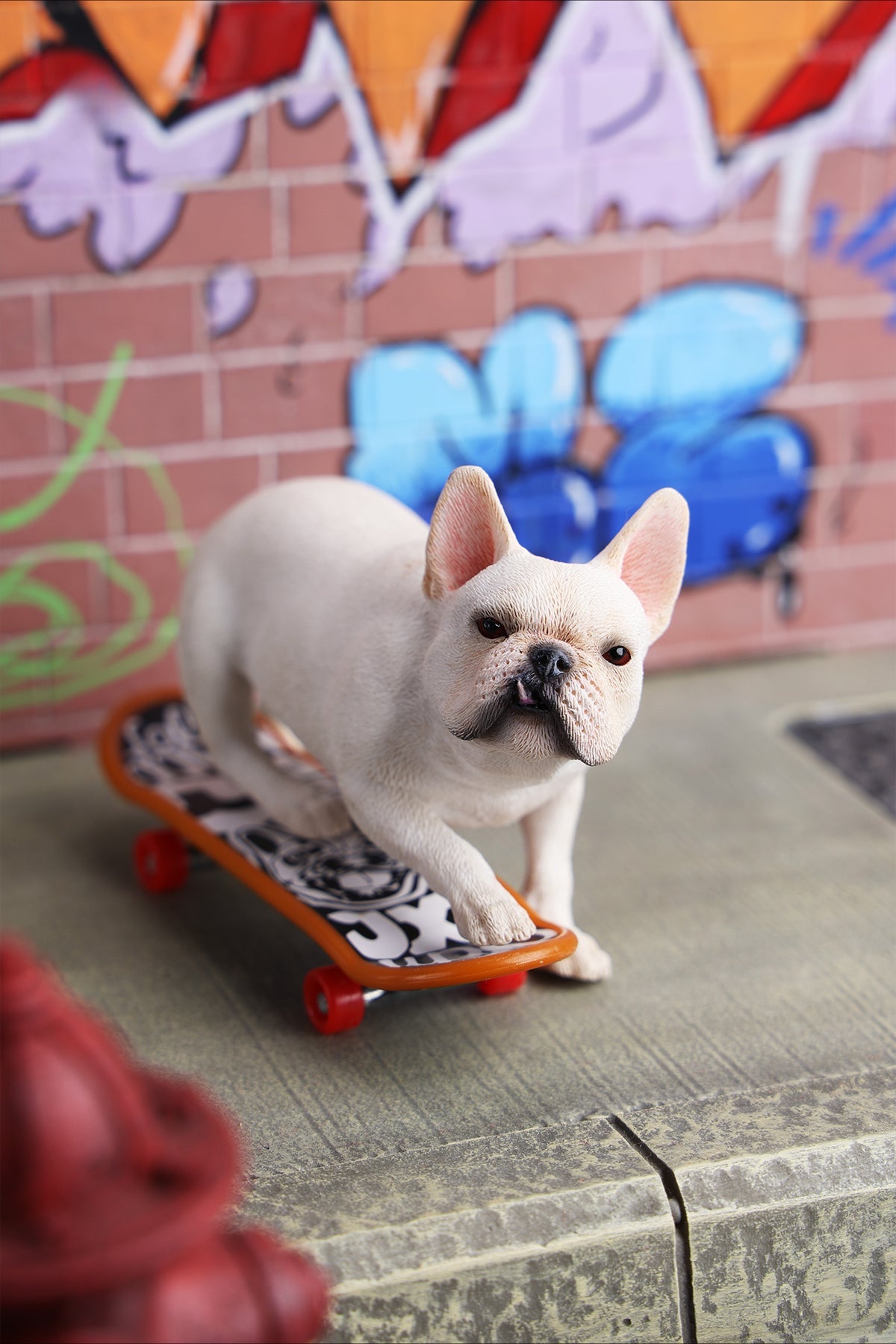 A detailed 1/6 scale figurine of a French Bulldog riding a skateboard, showcasing lifelike texture and joyful expression. Perfect for dog lovers and collectors.