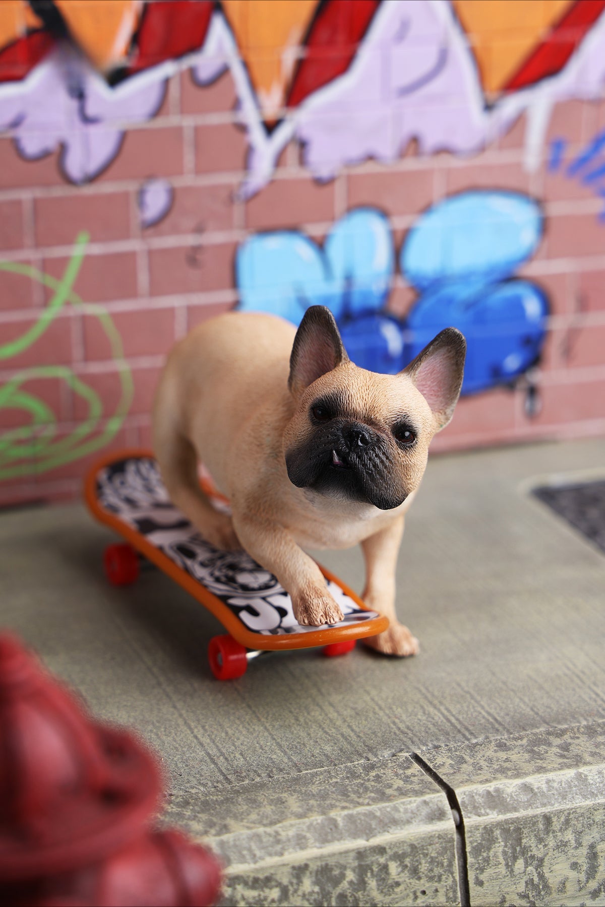 A detailed 1/6 scale figurine of a French Bulldog riding a skateboard, showcasing lifelike texture and joyful expression. Perfect for dog lovers and collectors.