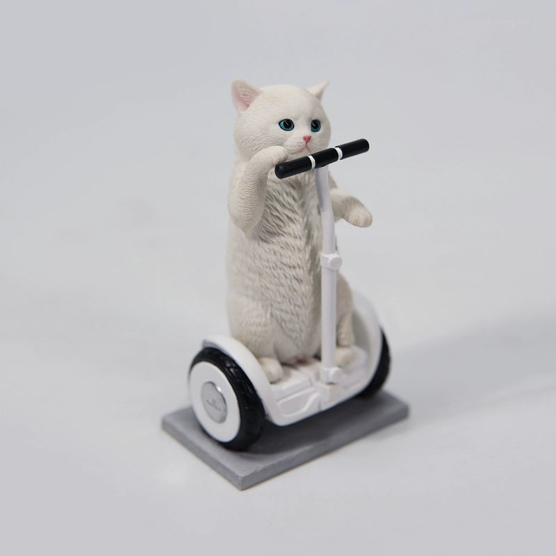 Adorable 1/6 scale Scottish Fold cat figurines, including a black-and-white, white, orange tabby, and grey cat, standing upright. One cat rides a balance car with a playful expression. These resin models showcase the breed's folded ears and expressive eyes, perfect for collectors.