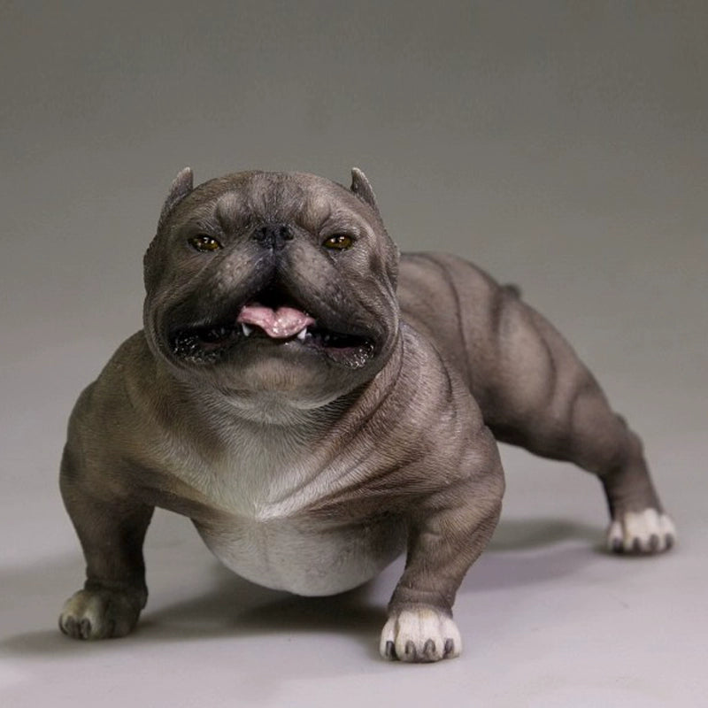 A group of 1/6 scale simulation American Bully dog models posed with a person. The figurines showcase various coat colors and muscular builds, with one close-up highlighting a white bully with a black patch around its eye. These detailed models capture the breed's powerful and robust appearance.