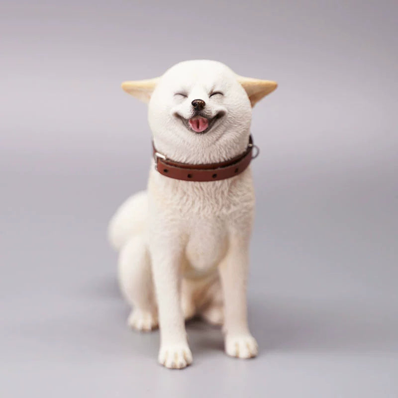 "Three realistic 1/6 scale Shiba Inu dog figurines in a sitting position, showcasing their adorable airplane ear feature. The figurines display three different coat colors: black and tan, red and white, and pure white. Each figurine is intricately detailed with a leather collar, capturing the breed's characteristic cheerful expression."