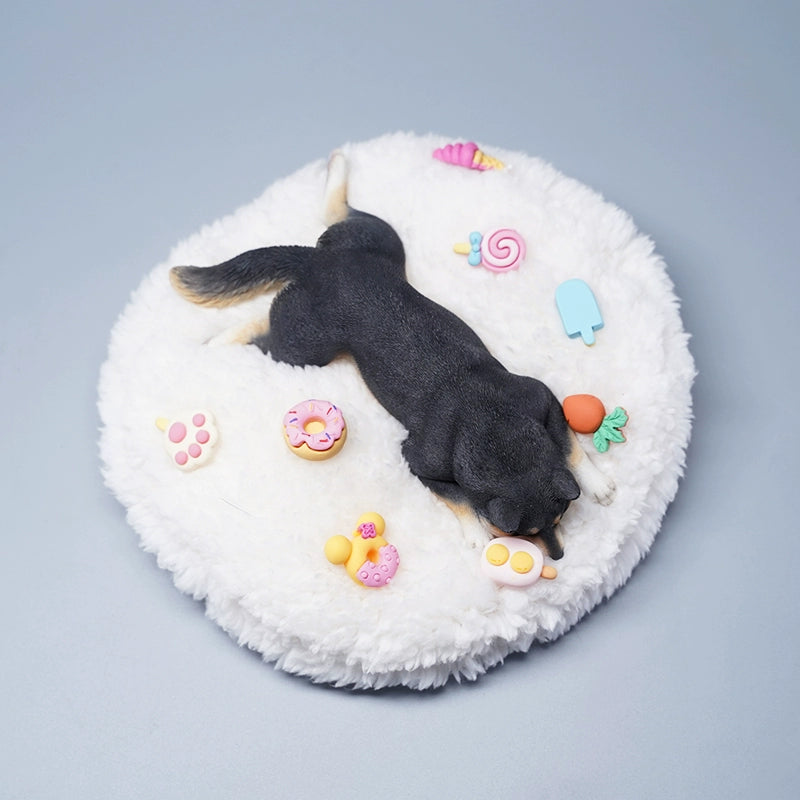A detailed resin model of a sleeping Shiba Inu dog on a fluffy white bed, surrounded by colorful toy replicas like a carrot, ice cream cone, donut, and paw print. The model captures the serene essence of a Shiba Inu with its realistic fur texture and lifelike posture, ideal for collectors and dog enthusiasts.