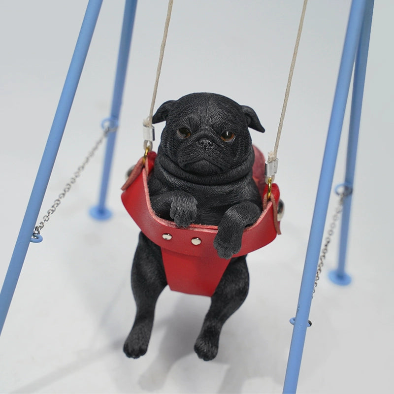 "1/6 scale pug dog figurines sitting in a red swing. These adorable and realistic models capture the playful nature of pugs, featuring lifelike details such as expressive faces and intricate fur textures. Ideal for dog lovers and collectors, these figurines add a touch of charm to any decor."