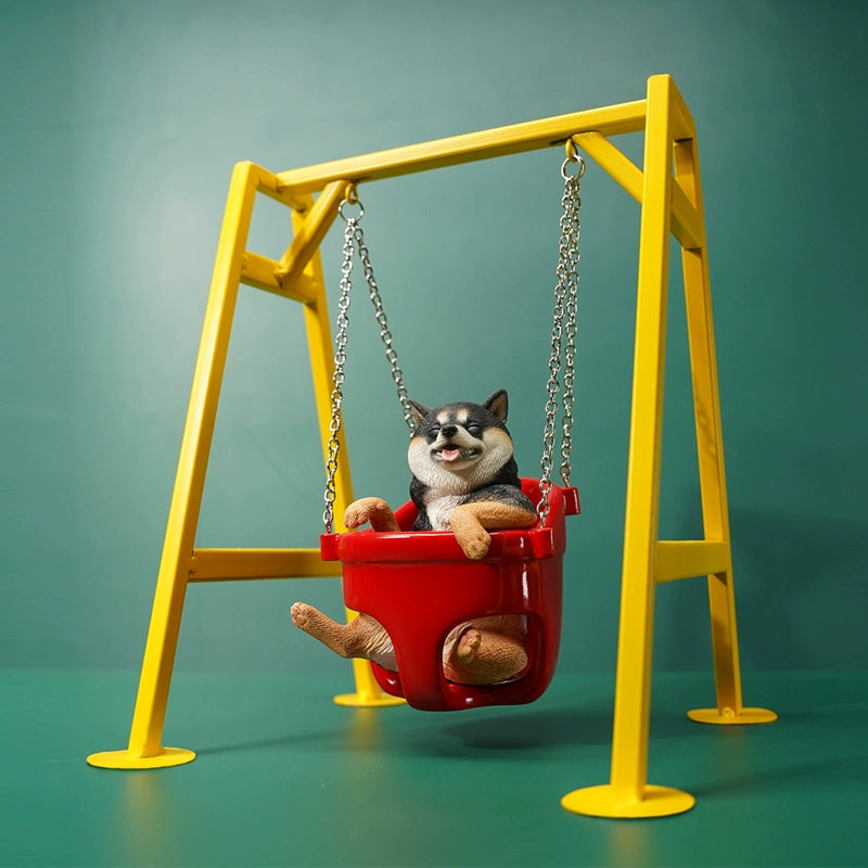 1/6 scale Shiba Inu dog figurines sitting in a red swing, mounted on a yellow frame. These lifelike models feature the cheerful expressions of Shiba Inus, detailed fur textures, and adorable poses. Perfect for collectors and dog lovers, these figurines bring a touch of playfulness and charm to any display setting.