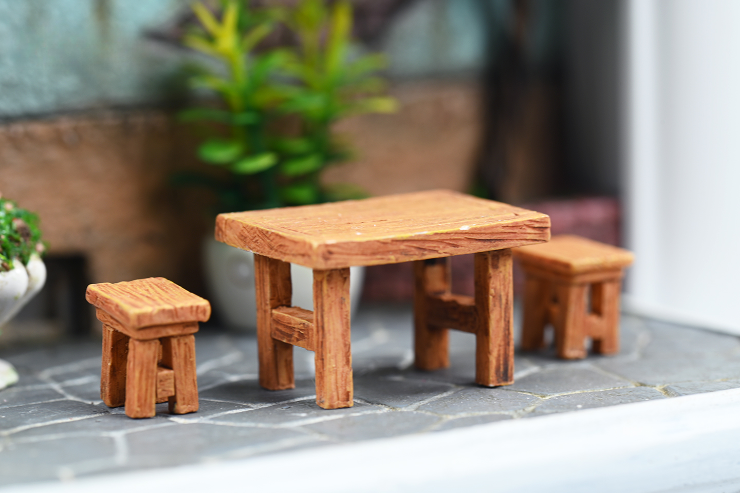 A detailed and charming art relief picture frame model featuring a white cat reaching up towards a window, surrounded by a beautifully crafted miniature garden with flowers, plants, and a rustic table with chairs. Perfect for adding a touch of whimsy and artistic flair to any room.