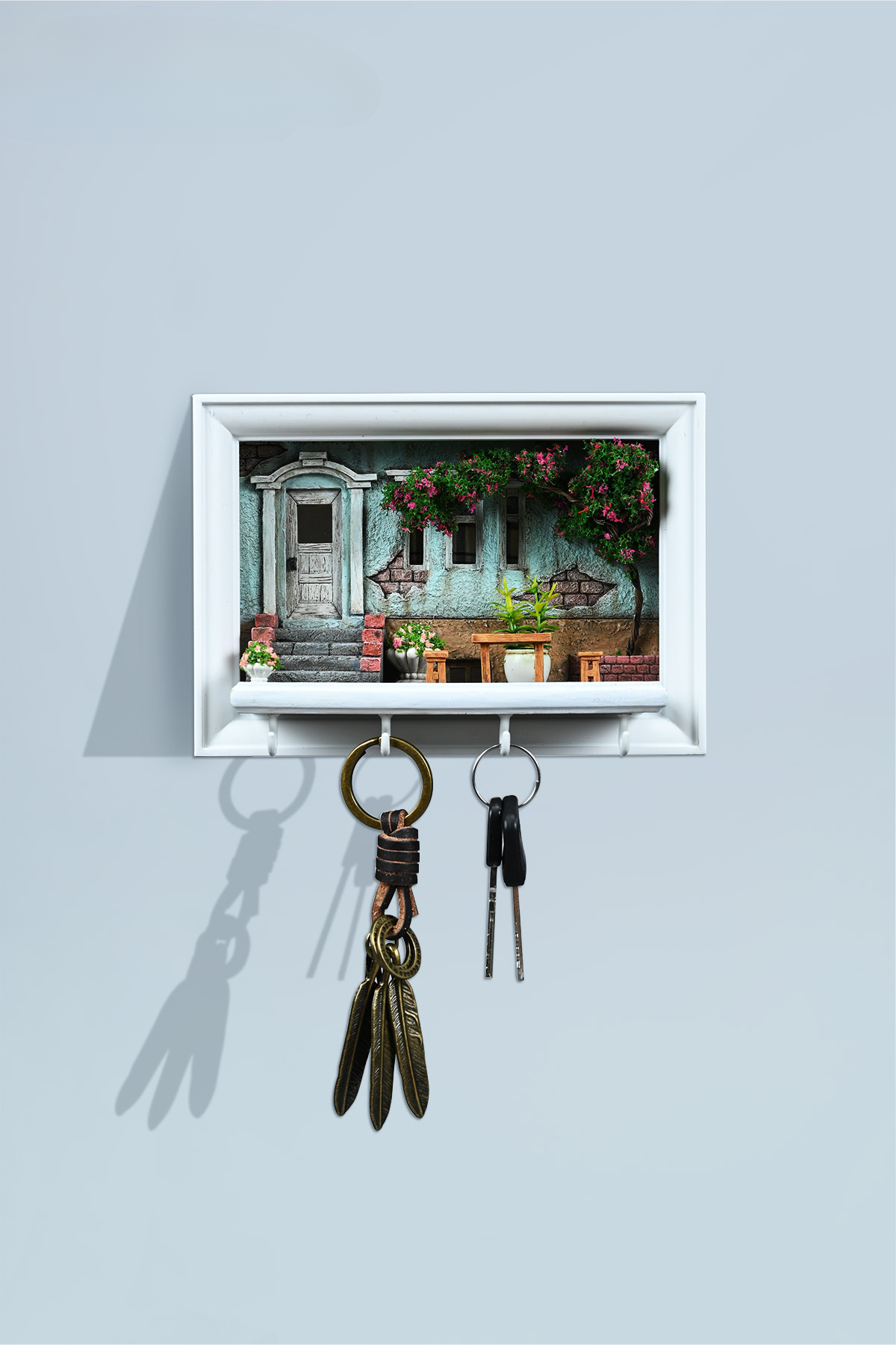 A detailed and charming art relief picture frame model featuring a white cat reaching up towards a window, surrounded by a beautifully crafted miniature garden with flowers, plants, and a rustic table with chairs. Perfect for adding a touch of whimsy and artistic flair to any room.