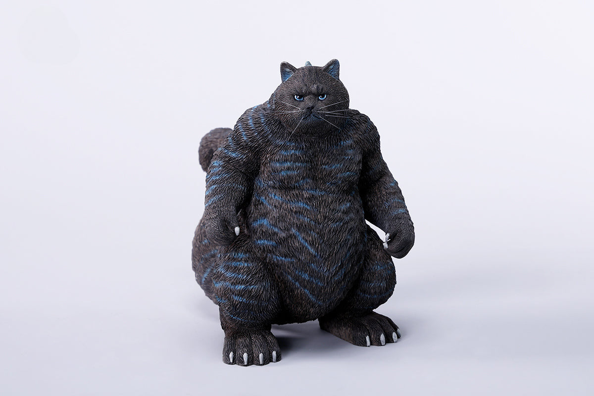 A striking model of Catzilla 2.0, showcasing a large, formidable cat figure breathing blue flames. The cat stands amid a miniature cityscape, featuring detailed buildings and structures, with another image displaying both the orange and black versions of the Catzilla model.