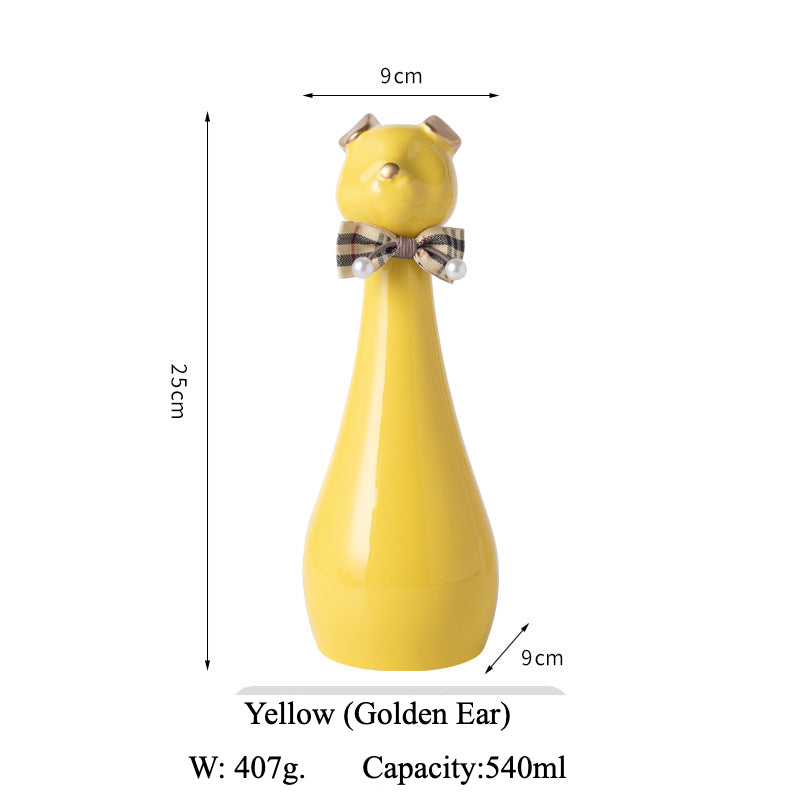 Yellow ceramic cat-shaped pet cremation urn with a glossy finish, featuring a stylish cat figure with a bow tie on a slender base, ideal for North American pet owners. This handcrafted urn provides secure ashes storage, perfect for home memorial display on mantels or shelves, with a vibrant yellow hue and elegant design.