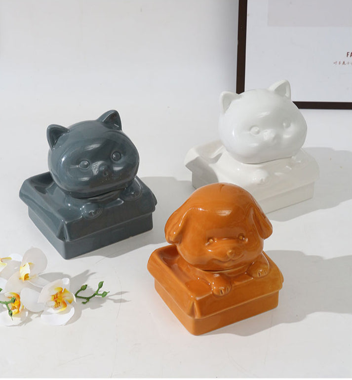 Orange ceramic dog-shaped pet urn with a glossy finish, featuring a cute dog figure on a square base, ideal for North American pet owners. This handcrafted memorial urn securely stores pet ashes, perfect for home display on mantels or shelves, offering a dignified tribute with its vibrant color and unique design.