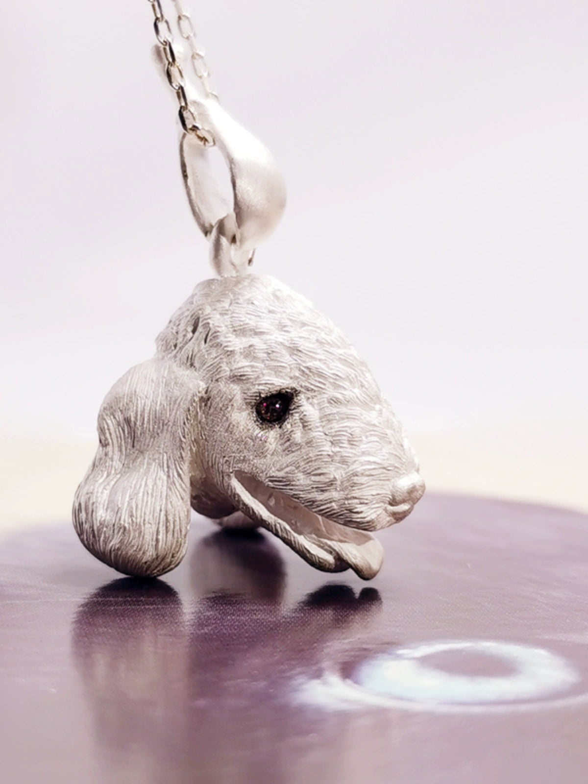 Close-up image of the Chameleon Bellington Pendant, showcasing intricate handcrafted details in 925 silver with gemstone eyes. The pendant captures the essence of the Bellington dog, highlighting fine fur texture and expressive features. Available in silver or antique black finish.