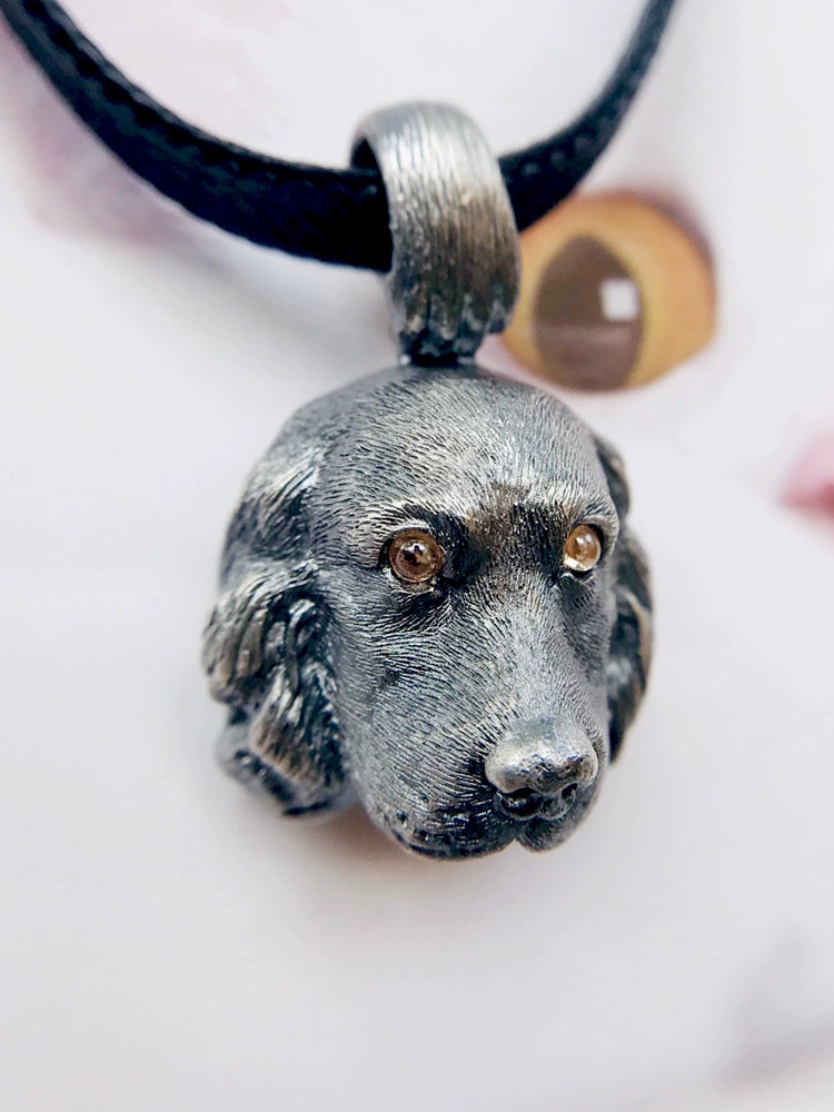 Close-up of a handcrafted Cocker Spaniel pendant in 925 silver, featuring detailed sculpting and gemstone eyes. Available in silver and antique black finishes, with options for custom engraving to create a personalized pet memorial.