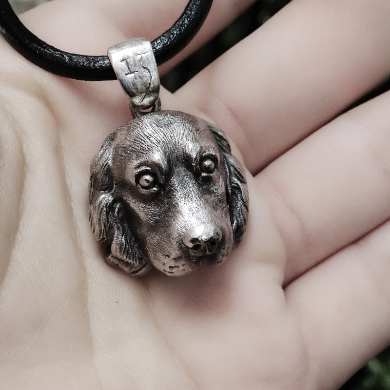 Close-up of a handcrafted Cocker Spaniel pendant in 925 silver, featuring detailed sculpting and gemstone eyes. Available in silver and antique black finishes, with options for custom engraving to create a personalized pet memorial.