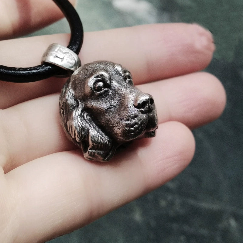 Close-up of a handcrafted Cocker Spaniel pendant in 925 silver, featuring detailed sculpting and gemstone eyes. Available in silver and antique black finishes, with options for custom engraving to create a personalized pet memorial.