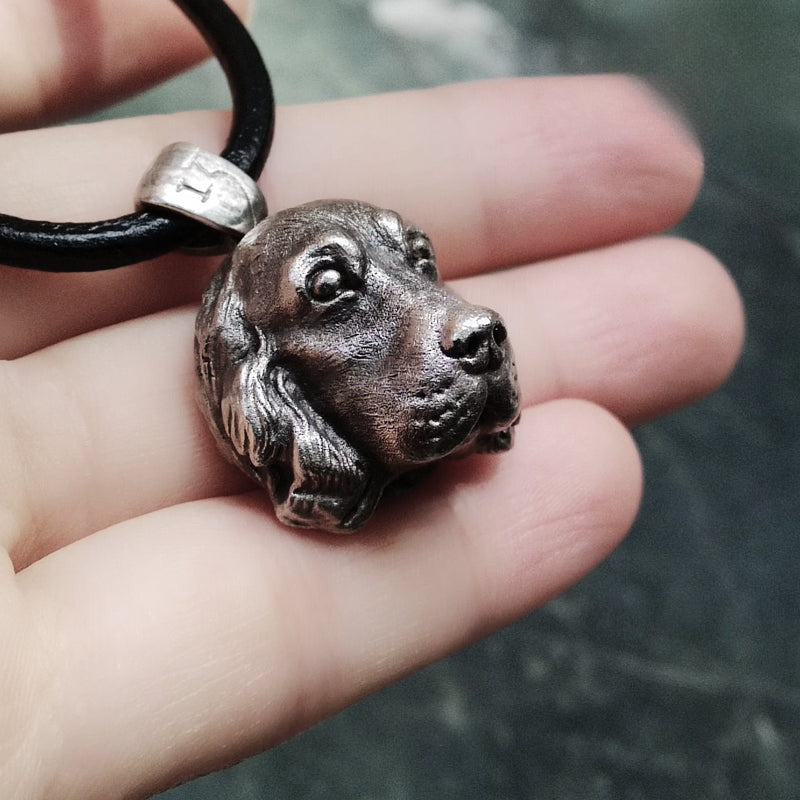 Close-up of a handcrafted Cocker Spaniel pendant in 925 silver, featuring detailed sculpting and gemstone eyes. Available in silver and antique black finishes, with options for custom engraving to create a personalized pet memorial.